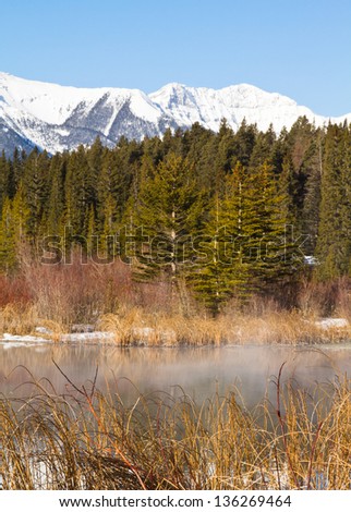 Thermal spring at the 3rd Vermilion Lake produces fog on the water on a chilly spring morning at Banff National Park, canada. Sundance Mountain Range in background.