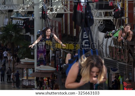 LAS VEGAS, NEVADA- OCTOBER 3, 2015: Three women fly over Fremont Street in downtown Las Vegas on the SlotZilla zip line attraction.