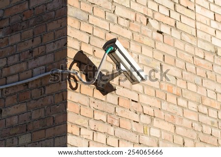 CCTV (security camera) on brick building wall background