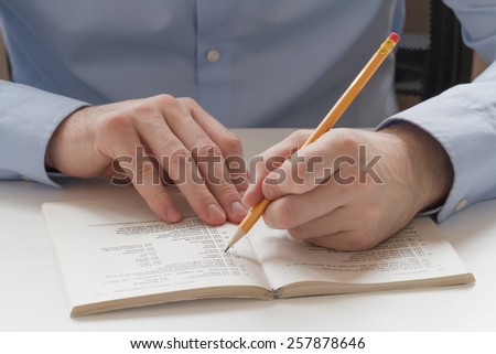 Educational concept. Student mark the correct answer in the test book and preparing for the exam
