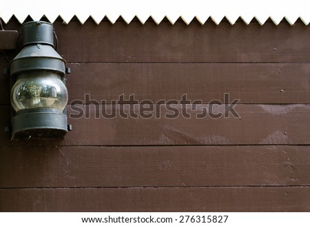 Old lamp in the corner on wooden wall with place for the text