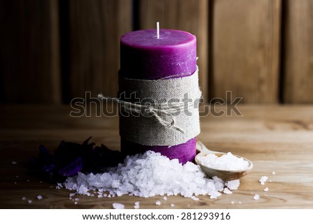 Handmade candles with heap of sea salt on wooden background