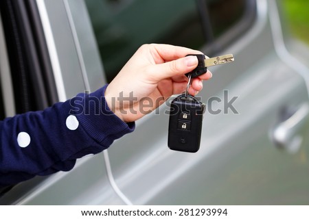 Auto dealership concept. Close-up view of car keys in the female hand