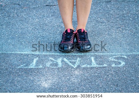 Sport woman in sneakers getting ready to run near the start line