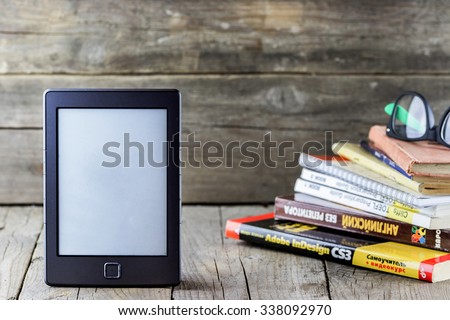 Ukraine, Kiev - October 25, 2015: Ebook reader with old books and glasses on wooden background