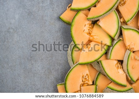 Cantaloupe melon slices, food border background, top view.