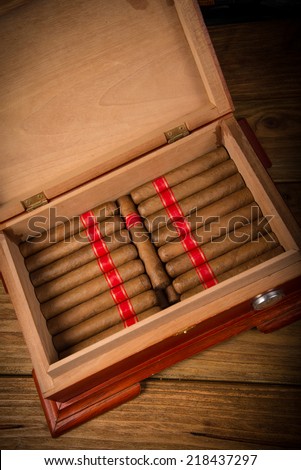 Cuban cigars and humidor on rustic wooden table