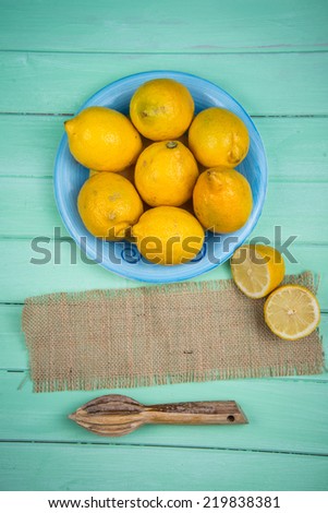 Market fresh organic lemons and juice squeezer on wooden table background with copy space
