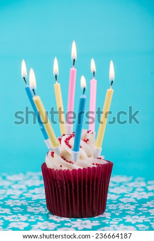 birthday cup cake with number five candle on blue background