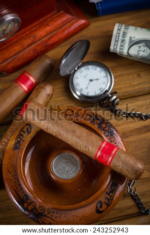 Rich person desk with cuban cigar, dollar notes and expensive watch