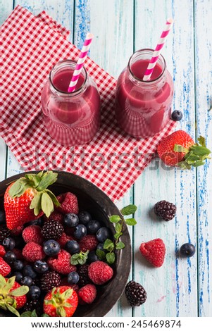 Homemade berries smoothie in vintage milk bottles