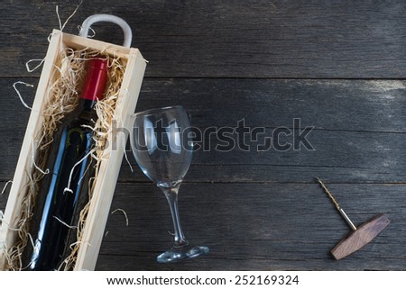 Wooden wine case with red wine on rustic background