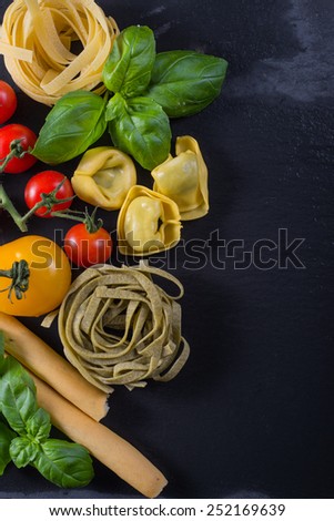 Selection of italian typical food on black background from above