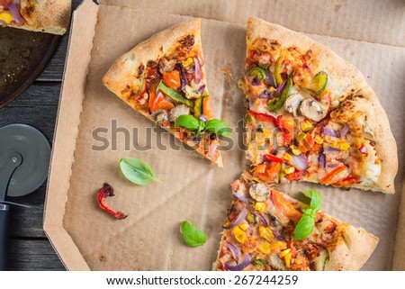 slices of homemade vegetarian pizza in box from above