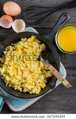 scrambled eggs in vintage frying iron pan, overhead view