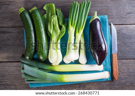 Farm fresh spring vegetables on board on wooden table from above