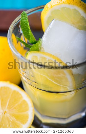 Refreshing lemonade with fresh citrus , mint and ice in glass on black background