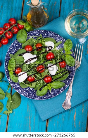 Healthy diet salad with tomatoes, mozzarella,basil and balsamic vinegar on plate