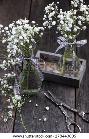 freshly cut wild meadow white flowers in mason jar on wooden rustic table