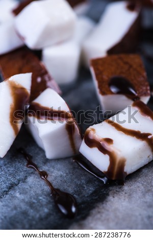 Coconut bits with chocolate on marble serving board