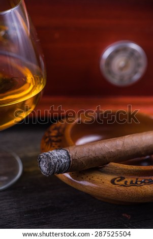 Cuban cigar,humidor and rum on wooden rustic table