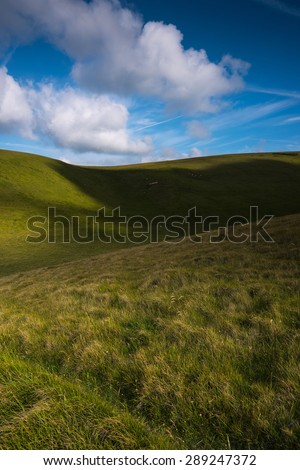 Rolling green hills with blue sky with clouds
