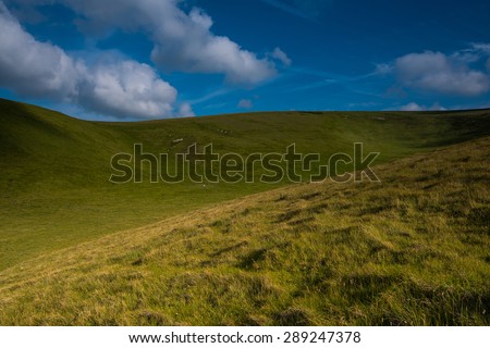 Rolling green hills with blue sky with clouds