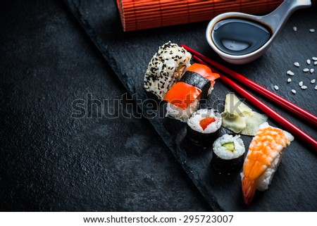 Sushi selection on black slate, food border background