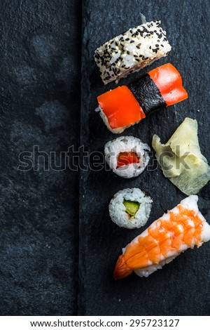 Sushi selection on black slate, food border background