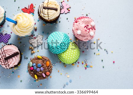 Vibrant cupcakes on blue background, party food concept, overhead