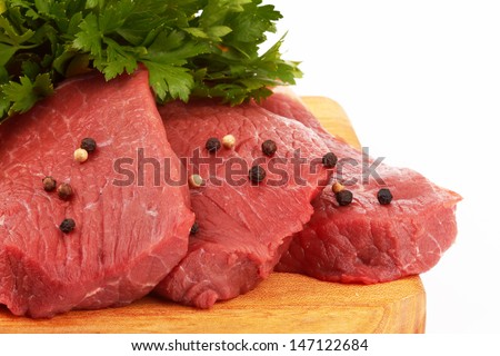 fresh raw beef meat slices over a wooden board