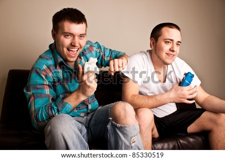 Two attractive guys having fun while playing video games