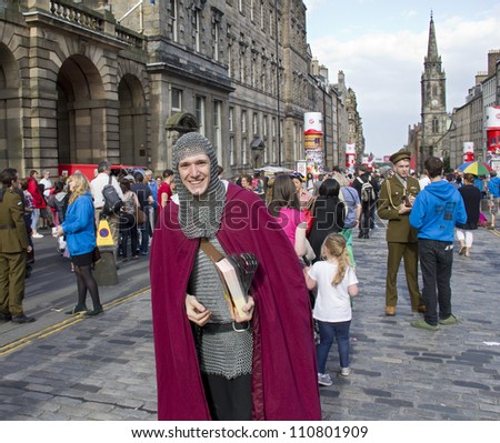 EDINBURGH, UK AUGUST 2: Unidentified man dressed as a medieval knight hands out flyers on the street at the Edinburgh Festival Fringe in Edinburgh, UK on August 2, 2012