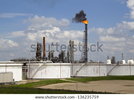 Fire and smoke from an oil refinery pipe with silos in Rotterdam industrial area in Holland