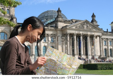 Berlin: Girl with map at Reichstag building. Focus on girl.