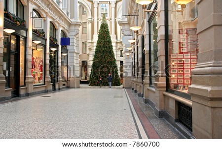 Shopping arcade with christmas tree, including a father and son wearing father christmas caps