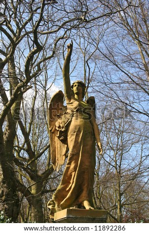 Stone angel in a 19th century cemetery pointing to heaven