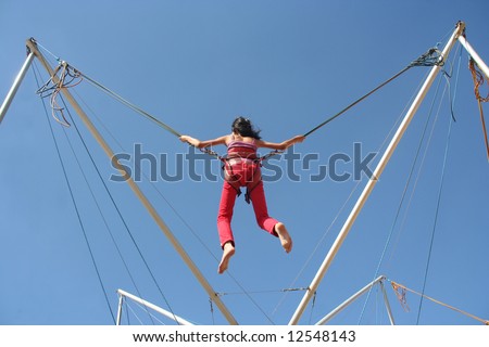 Girl bungee jumping on a trampoline