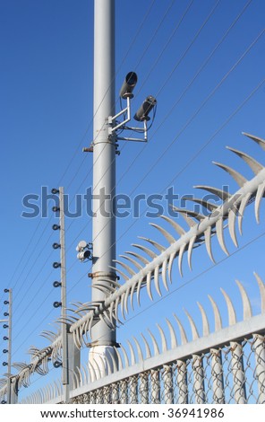 High security fence with video cameras and electric wire