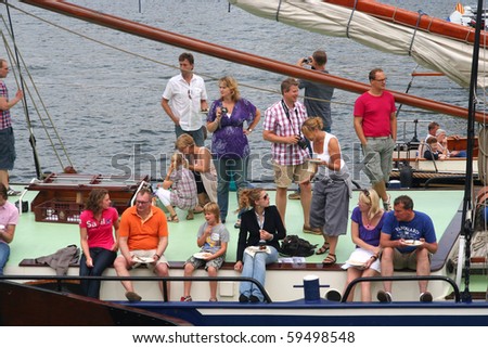 AMSTERDAM-AUGUST 19: People on a boat participating in Sail 2010 on August 19, 2010 in Amsterdam, Holland