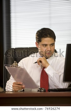 Hispanic Business Man Looking at Computer in the Office