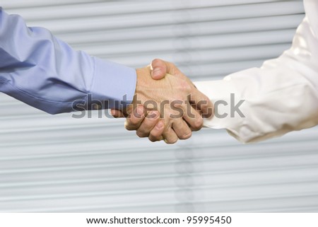 Closeup of two Caucasian men shaking hands.