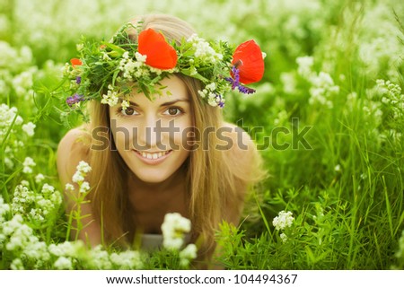 Beautiful young girl with diadem on green field