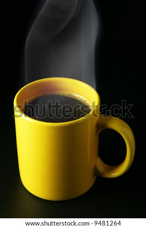 Yellow coffee cup with steam over black background