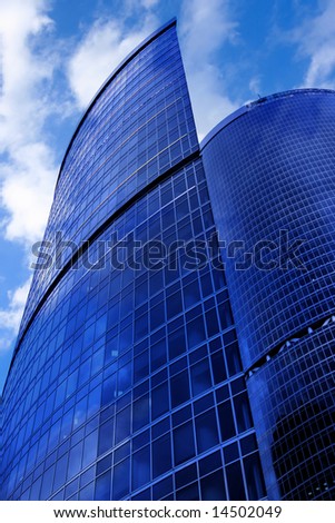 Modern skyscrapers close-up under blue sky with clouds
