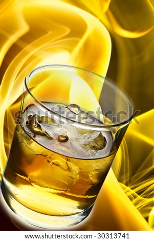 Glass of whisky with ice and fire in the background
