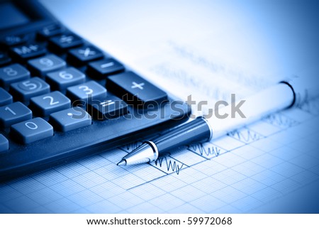 Profit bar chart, pen and calculator. Shallow DOF! Focus on the pen.