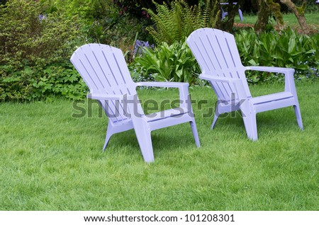 A setting of purple chairs on a green lawn ready to enjoy