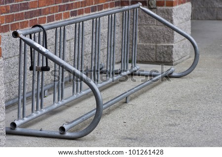 An empty bicycle rack with abandoned bike lock