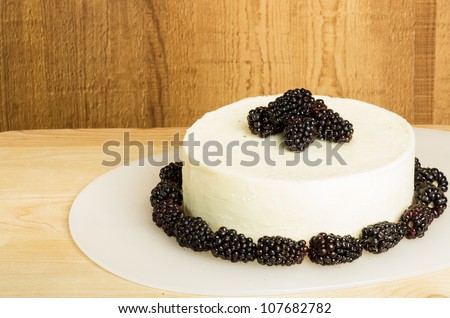 A block of white cheddar cheese with blackberries